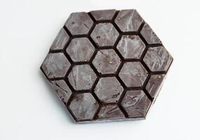 Handmade dark chocolate bar. Homemade Chocolate bark in shape of honeycomb. Top view. Isolated on white background. Copy space photo