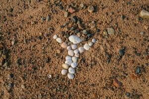 un pequeño hombre figura hecho de arena y conchas en el mar playa. letonia, báltico, golf de riga. Copiar espacio. ingenuo Arte. niños artesanía, Arte pedazo. pasatiempo artista. simbolismo foto