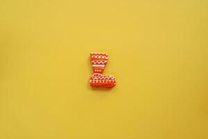 Glazed colorful gingerbread boot lies on a yellow background photo