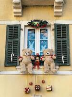 Christmas decorations hanging from the window sill of an old stone house photo