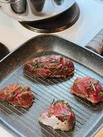 Pieces of meat with rosemary are fried in a grill pan photo