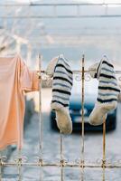 Washed T-shirt next to knitted socks dries on a metal grate photo