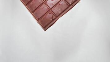 grand Lait Chocolat bar avec Geler séché des fraises et des noisettes amandes sur isolé blanc Contexte fermer video