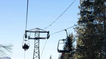 osservazione sollevamento nel il inverno montagne su il sfondo di il cielo. persone siamo rilassante e godendo il Natale vacanze nel sciare ricorrere video