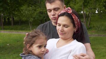 madre affettuoso bacio su il Childs fronte trasporta sua in profondità amore e preoccupazione. padre posti un' rassicurante mano su il suo figlie spalla, fornire addizionale supporto video