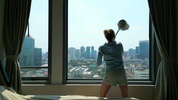 Woman cleaning a window in an apartment in a skyscraper. video