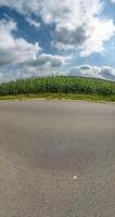 vertical little planet transformation with curvature of space on road in blue sky with clouds video