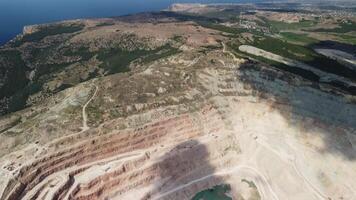 Aerial view industrial of opencast mining quarry with lots of machinery at work - extracting fluxes for the metal industry. Oval mining industrial crater, acid mine drainage in rock. video