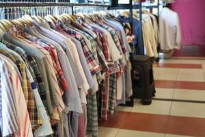 un fila de ropa colgando en un estante en un almacenar. adecuado para Moda y Al por menor conceptos foto