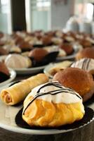 Bunch of snack cakes on plate. Many rows of plates with buffet snacks. photo