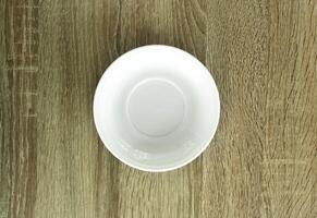 Empty white plate on wooden table, view from above. Image with copy space. Top view with copy space. photo