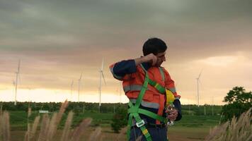 Smart engineer wearing protective helmet drinking water while  working at electrical turbines field video