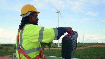 A smart engineer is putting a protective helmet on head at electrical turbines field video