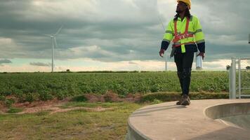 Smart engineer with protective helmet holding the blueprint working at electrical turbines field video