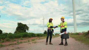 Smart engineers with protective helmet shaking hands at electrical turbines field video