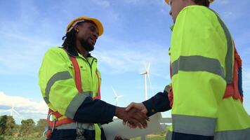 Smart engineer with protective helmet holding the blueprint working at electrical turbines field video