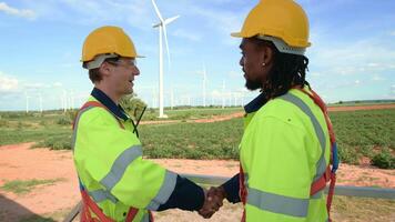 Smart engineers with protective helmet shaking hands at electrical turbines field video