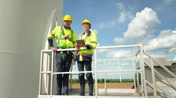 Smart engineer with protective helmet holding the blueprint working at electrical turbines field video