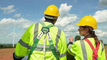 Smart engineer with protective helmet holding the blueprint working at electrical turbines field video