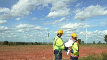 Smart engineer with protective helmet holding the blueprint working at electrical turbines field video