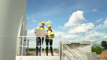 Smart engineer with protective helmet holding the blueprint working at electrical turbines field video