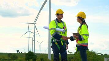 Smart engineers with protective helmet shaking hands at electrical turbines field video