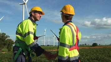 smart ingenjörer med skyddande hjälm skakning händer på elektrisk turbiner fält video