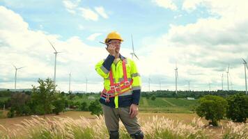 un inteligente ingeniero con protector casco en cabeza, utilizando walkie película sonora a eléctrico turbinas campo video