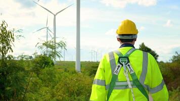 en smart ingenjör med skyddande hjälm på huvud, använder sig av walkie prat på elektrisk turbiner fält video