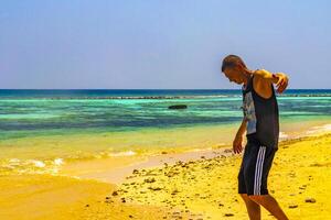 Happy man in water and on paradise tropical beach Maldives. photo