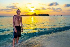 Kuramathi Maldives tropical paradise island sunset man handsome male tourist. photo