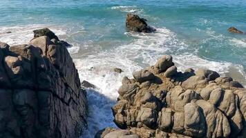 skön stenar klippor surfare vågor på strand puerto escondido Mexiko. video