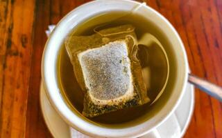 White cup of tea with tea bag on table Mexico. photo