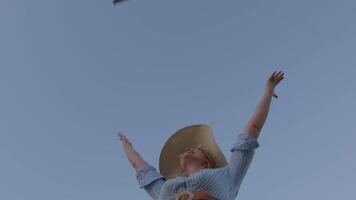 Joyful woman raising arms to airplane above video