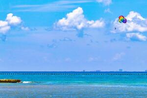 Tropical Caribbean beach people parasols fun Playa del Carmen Mexico. photo