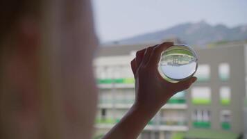 Girl holding crystal ball with upside-down city view video