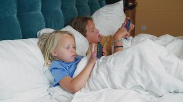 Children using gadgets in bed video