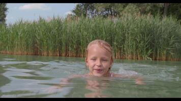 Young girl swimming in natural water body video