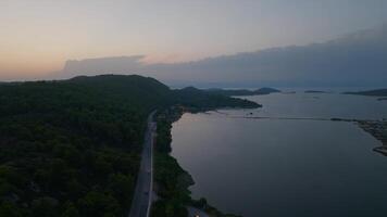 crepúsculo sobre costeiro estrada e lagoa video