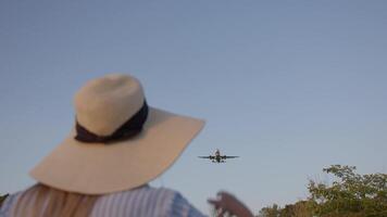 mujer en sombrero sonriente a aterrizaje avión video