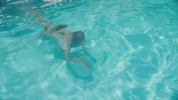 Six-Year-Old Girl Dives to Retrieve Her Googles in a Sunlit Swimming Pool video