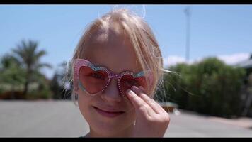 de bonne humeur Jeune fille portant en forme de coeur des lunettes de soleil video