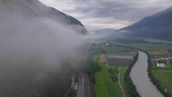 antenn antal fot av Drönare flygande genom moln med se av väg Nedan i dolomiter österrike video
