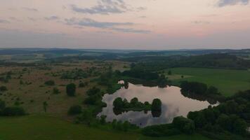 Aerial view of expansive forest lake at sunset video