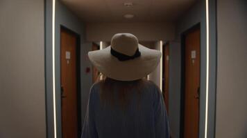 Woman in hat walking down hotel corridor video