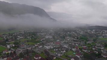 antenne filmische vooruit beweging over- mistig dorp in dolomieten Oostenrijk video