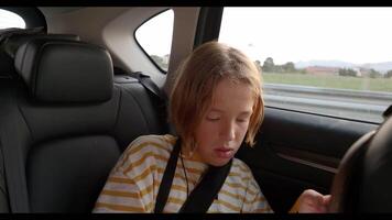 niño jugando en teléfono inteligente en coche asiento trasero video