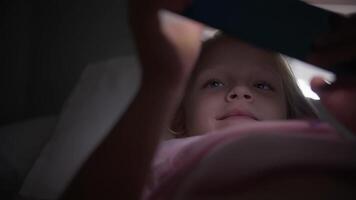 menina jogando em telefone dentro cama video