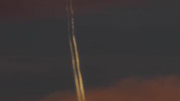 Airplane with contrail at orange sunset video
