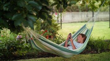 jeugd innemend met digitaal inhoud in een sereen tuin instelling video